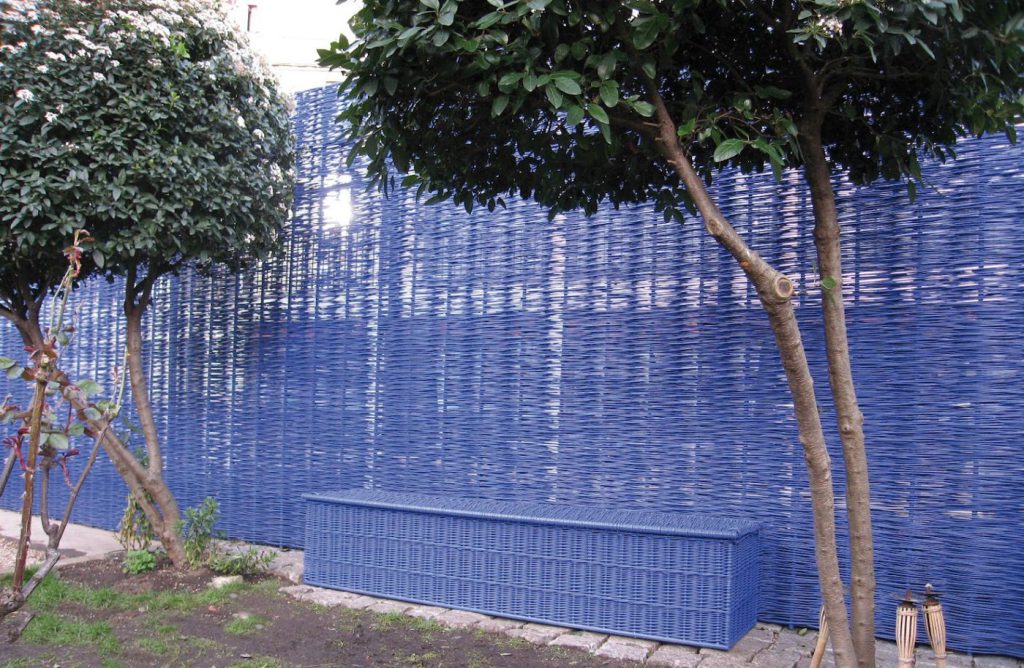 Écran d'osier teinté bleu dans un jardin