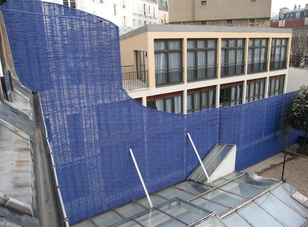 Haut écran d'osier bleu devant un bâtiment